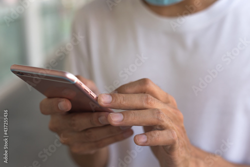 Men's hands use a smartphone for online shopping, social networking, or remote work. Close up image.