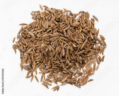 top view of pile of caraway seeds close up on gray photo
