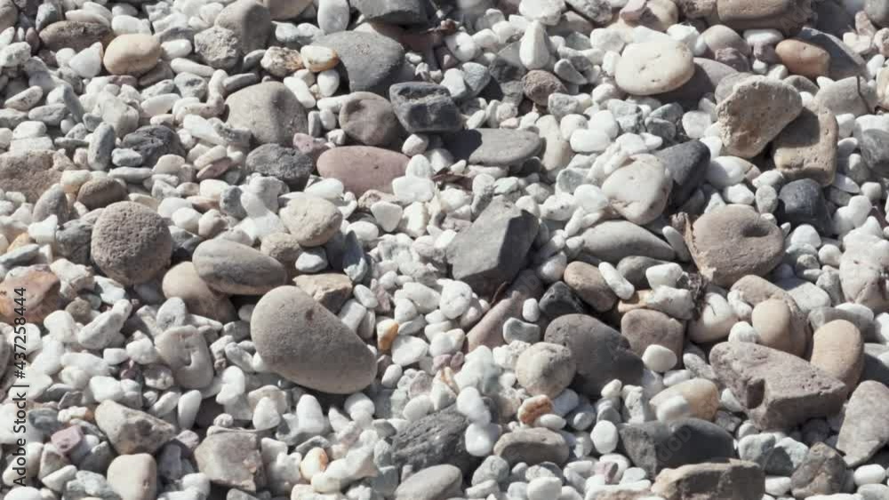 Dropping beautiful stones on other stones, static close up view Dropping beautiful stones on other stones, static close up view