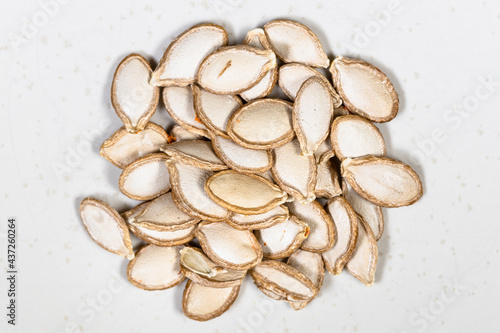 pile of whole pumpkin seeds close up on gray
