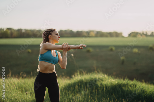 Woman in sportswear training in morning nature.