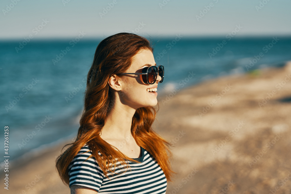 happy red-haired woman in sunglasses by the sea fun emotions