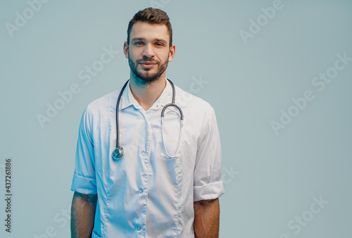 Positive young european male doctor in studio