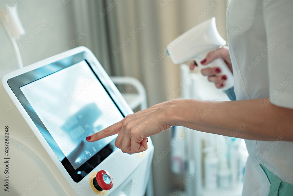Obraz premium A woman beautician makes a diode laser epilation procedure.
