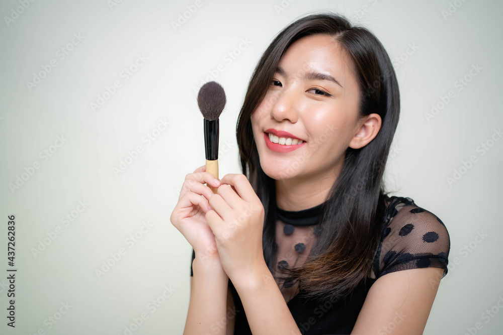 Asian women are applying foundation at the makeup table in the dressing room. Asian women are applying foundation at the makeup table in the dressing room.