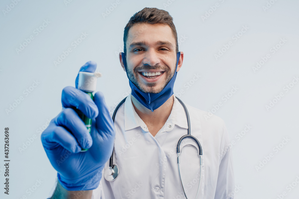 Smiling male doctor showing inhaler in studio Smiling male doctor showing inhaler in studio