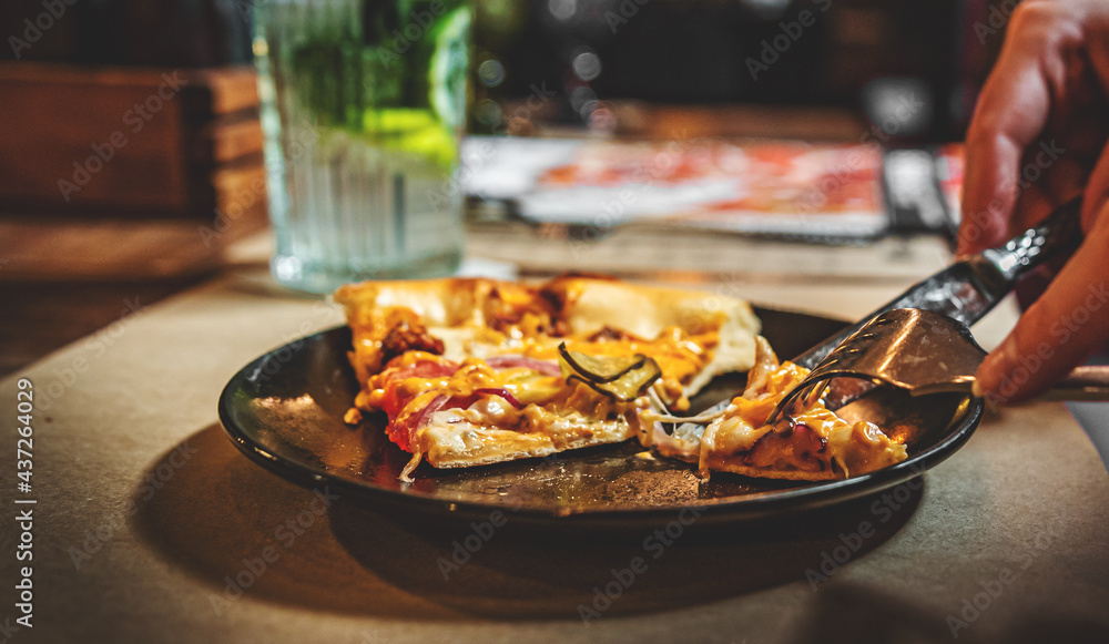 woman hands with knife and fork cutting pizza on table in cafe woman hands with knife and fork cutting pizza on table in cafe