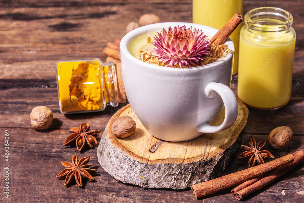 Golden turmeric milk with ice on bright yellow background Golden turmeric milk with ice on bright yellow background