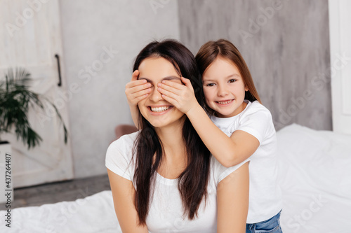 Mirthful girl having fun with her mother