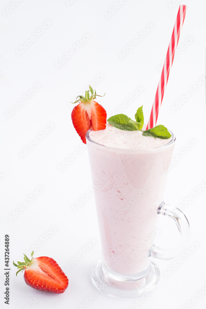 Strawberry milkshake in the drinking glass on the white background. Location vertical. Strawberry milkshake in the drinking glass on the white background. Location vertical.