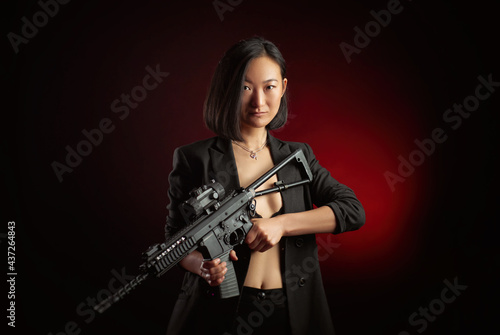 asian woman in a jacket with an automatic rifle in her hands mafia fighter
