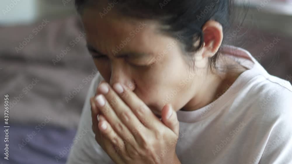close up asian woman cough sneeze and covering mouth with the hand close up asian woman cough sneeze and covering mouth with the hand