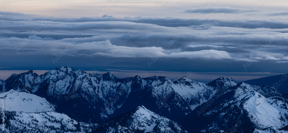 Obraz premium Aerial View from Airplane of Canadian Mountain Landscape in Spring time. Colorful Sunset Sky. North of Vancouver, British Columbia, Canada. Authentic Image