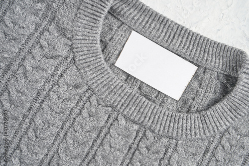 Closeup of an inner label on the neck of a pretty gray wool sweater. Blank space to place a logo, text or image