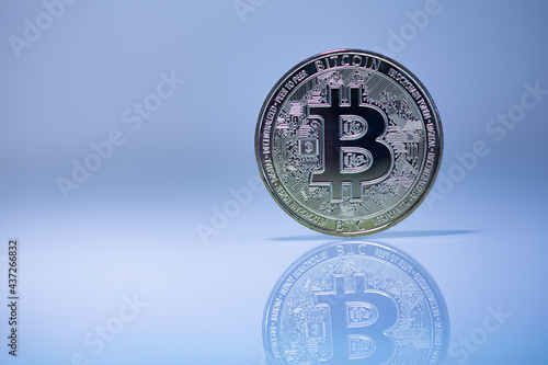 Bitcoin BTC cryptocurrency physical coin placed on the reflective surface
