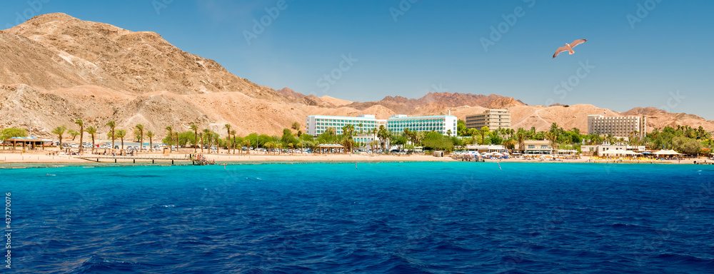 Panoramic view on sandy beach and hotels for divers and vacationers, the area located near coral reefs in Eilat - famous tourist resort city in Israel, Middle East