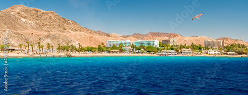Panoramic view on sandy beach and hotels for divers and vacationers, the area located near coral reefs in Eilat - famous tourist resort city in Israel, Middle East