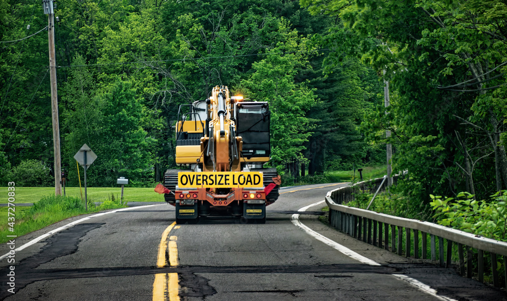 A truck carrying an oversize load enters a turn on the already heavily