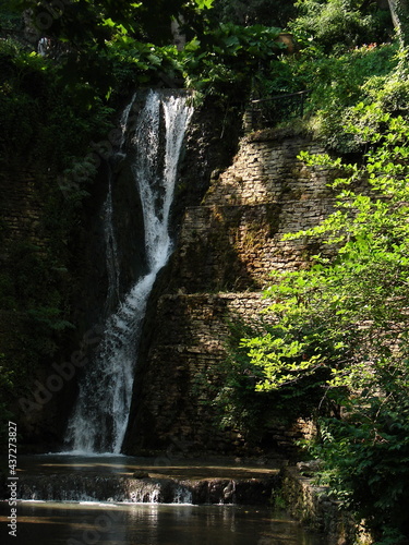 naturalny wodospad na skale wśród zieleni - pionowo
