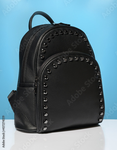 Black leather casual backpack on blue background