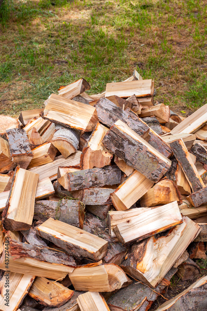 Chopped wood in a heap outside, prepared for the winter to heat the house. Fuel for stove and fireplace Chopped wood in a heap outside, prepared for the winter to heat the house. Fuel for stove and fireplace