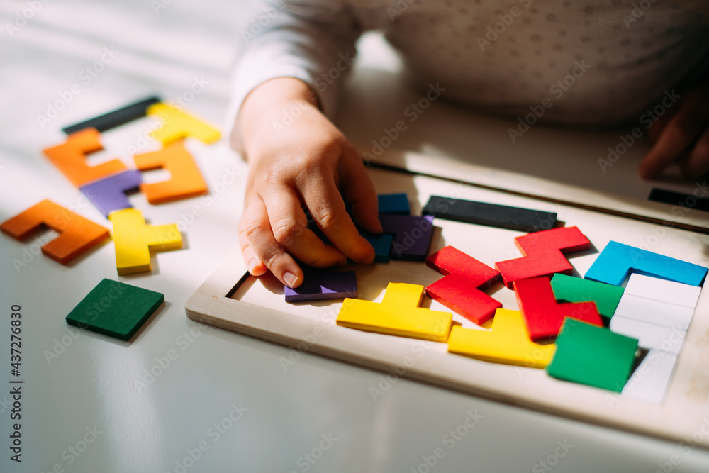 A child playing a colored puzzle on the table