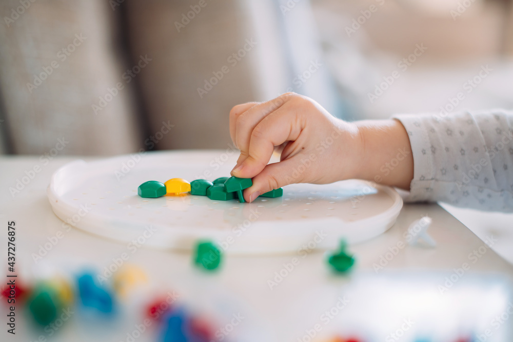 Child playing mosaic on the table close up Child playing mosaic on the table close up