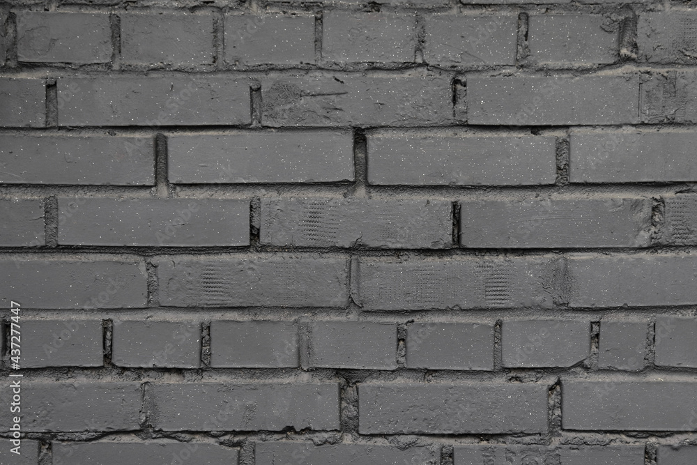 A gray brick wall. Background with a brickwork texture. The walls of street houses. Loft style. A gray brick wall. Background with a brickwork texture. The walls of street houses. Loft style.