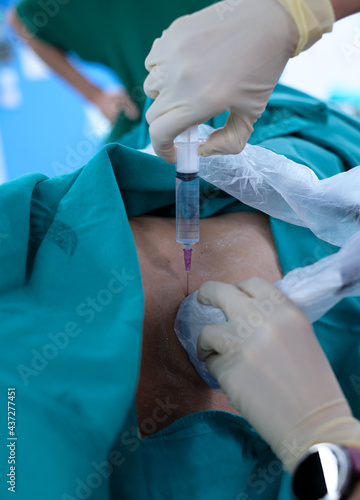 Anesthetist press ultrasound probe and injection more medication on the patient’s back for release pain in Epidural analgesia or Epidural nerve block procedure.