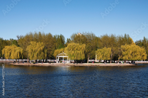 Scenic view of the island called Island of Love during spring sunset in the Taras Shevchenko Park. Green leaves trees are reflected in the pond. Famous touristic place and romantic travel destination