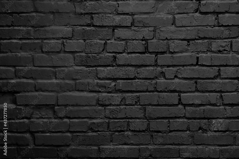 A black brick wall. Background with a brickwork texture. The walls of street houses. Loft style.