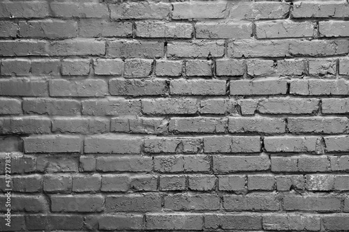 A gray brick wall. Background with a brickwork texture. The walls of street houses. Loft style.