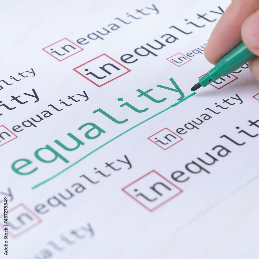 Obraz premium A hand with a green marker underlines the word EQUALITY surrounded by the words INEQUALITY.. Selective focus