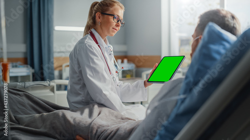 Hospital Ward  Friendly Female Doctor Talks to Sick Male Patient Resting in Bed  Shows Green Chroma Key Screen Tablet Computer  Explains Results. Physician Talks to Man Recovering after Surgery