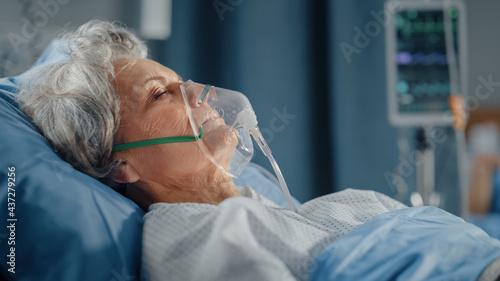 Hospital Ward: Portrait of Beautiful Elderly Woman Wearing Oxygen Mask Sleeping in Bed, Fully Recovering after Sickness and Successful Surgery. Senior Woman Dreaming of Her Family, Friends, Happy Life