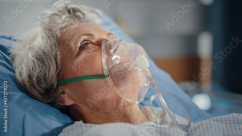 Hospital Ward: Portrait of Beautiful Elderly Woman Wearing Oxygen Mask Sleeping in Bed, Fully Recovering after Sickness. Old Lady Dreaming of Her Family, Friends, Happy Life. Close-up Shot