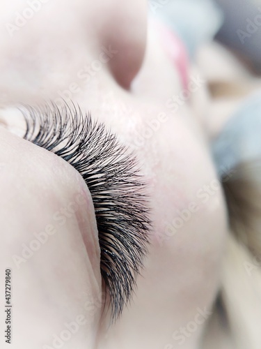 Lash extensions in beauty salon macro blue eye top view 