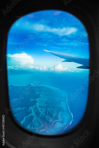 Plane view from window during flight above Tahiti island. Aerial landscape of Bora Bora island, French Polynesia vacation travel. Vertical. © Maridav