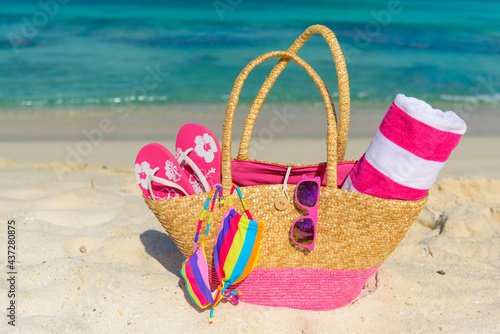 Beach bag, flip flops, beach towel on the shoreline, beautiful beach