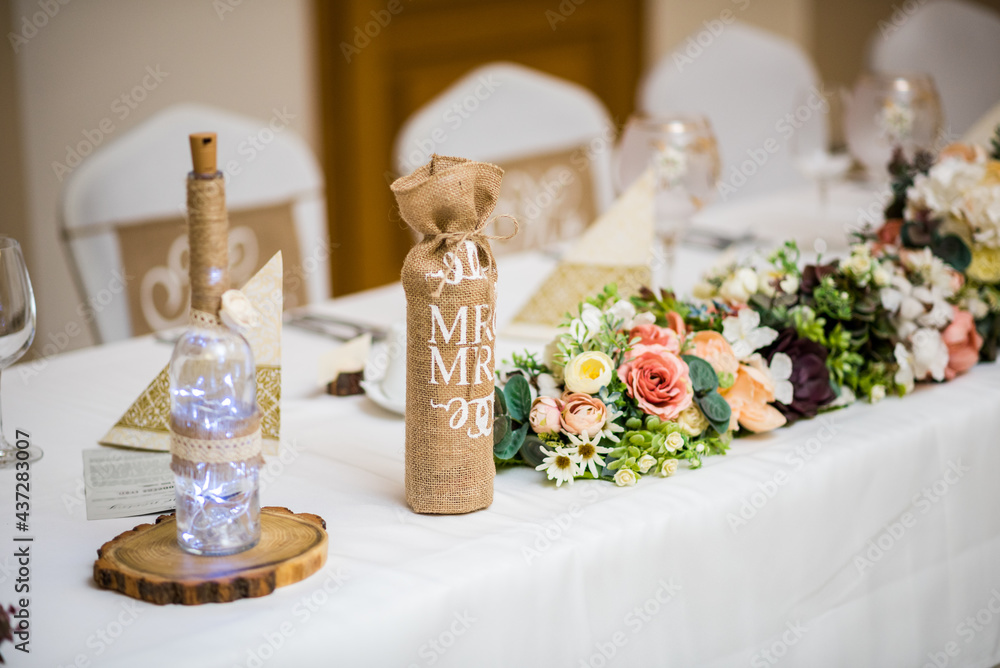 Naklejka premium Detail of flowers on a wedding table which is ready for the guests and bride with the groom.
