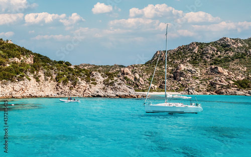 Sardinia, Italy, holidays. Yacht and boat in the sea with crystal clear azure water in a summer day.
