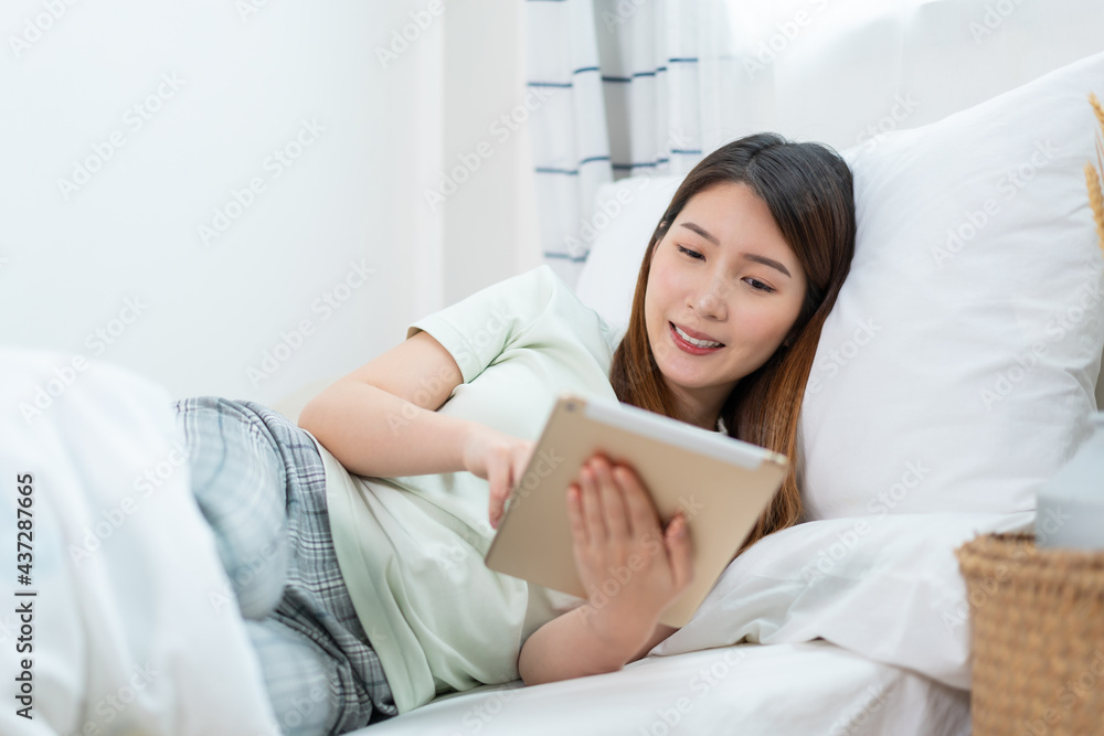 Asian woman using tablet working or browsing for online shopping at home while coronavirus pandemic Asian woman using tablet working or browsing for online shopping at home while coronavirus pandemic