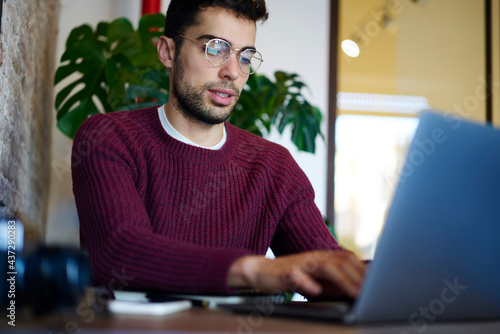 Focused self employed man working from cafe