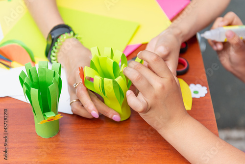 Girl makes paper crafts with her mother.