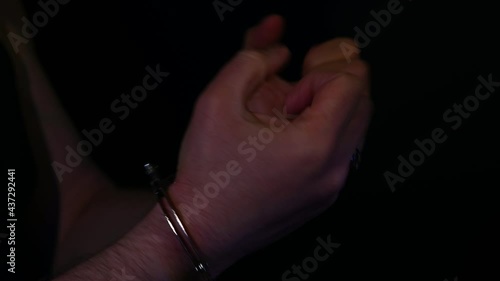 Criminal with cuffed hands in police lights