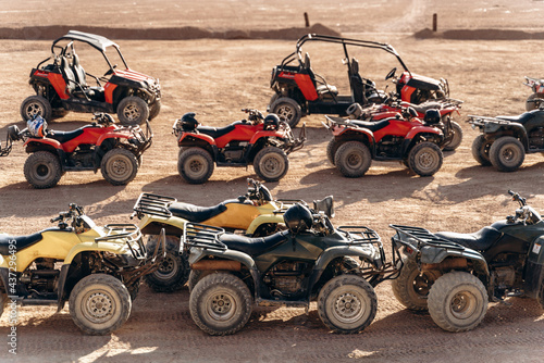 Large column of ATVs and buggies stands in the middle of a sandy desert. Ready for fun in the desert