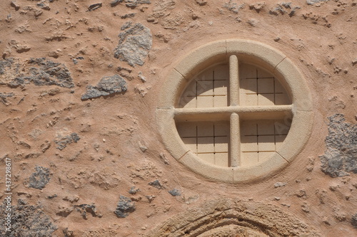 Okrągłe okno na murze malej cerkwi na Krecie, Grecja photo