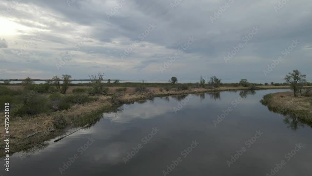 Drone flying low and slow above a calm river that is reflecting the blue and gray clouds.
Drone flying low and slow above a calm river that is reflecting the blue and gray clouds.