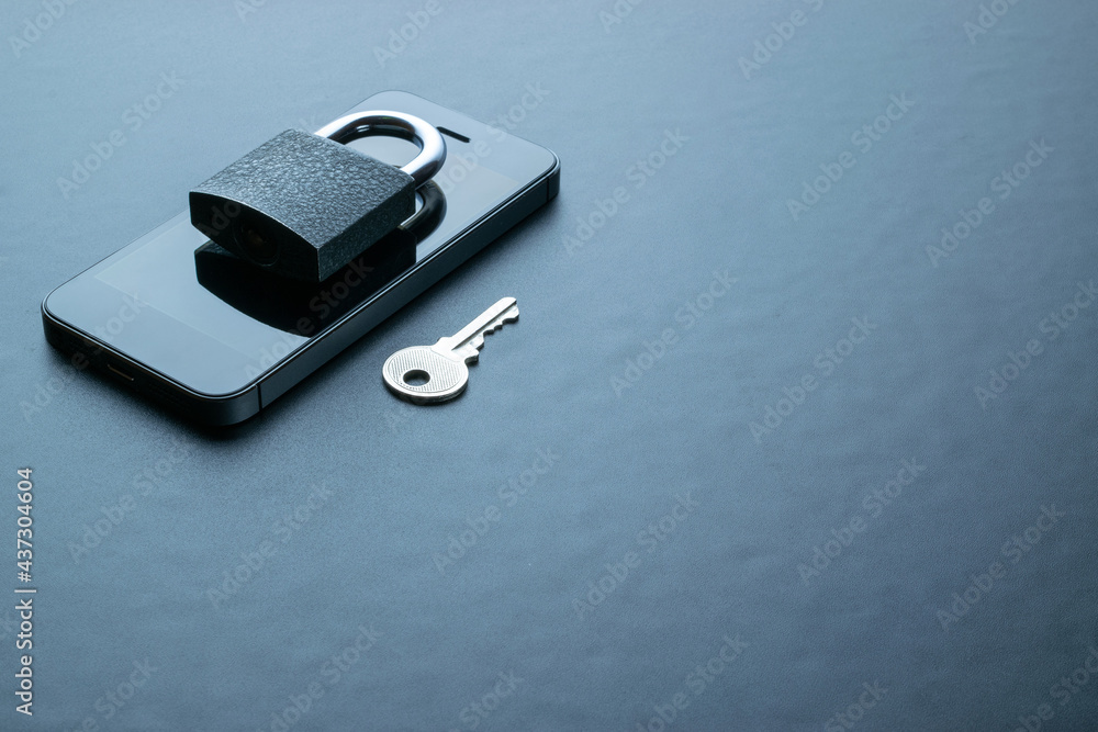 Business security protection. Modern space grey mobile phone with padlock, key on dark background. Smartphone fraud, online scam and cyber security threat. Business security protection. Modern space grey mobile phone with padlock, key on dark background. Smartphone fraud, online scam and cyber security threat.