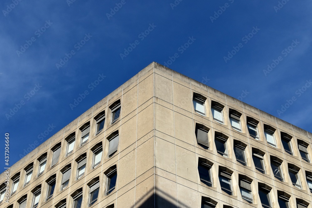 Facade of an office building with many windows and blue sky in the background